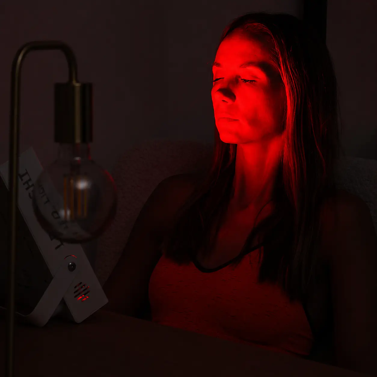 Twarz kobiety oświetlona czerwonym światłem lampy LED
